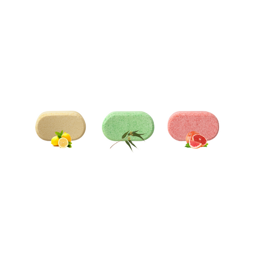 Three colorful eco-friendly multi surface spray cleaner tablets with fruit designs on a white background
