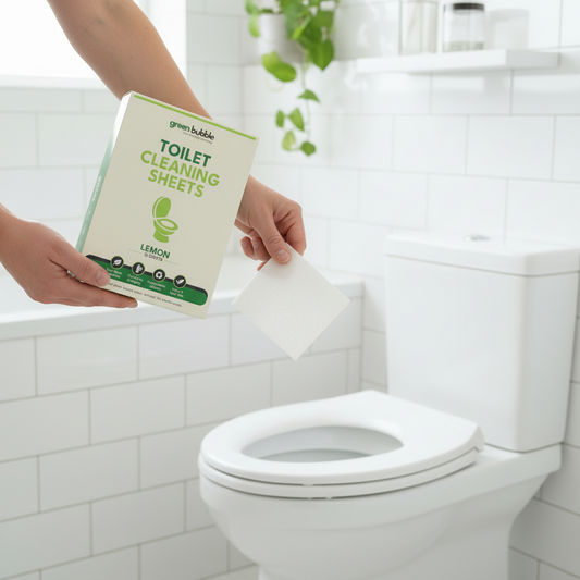 Person using green bubble toilet cleaning sheets in a bathroom.